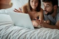 Happy in bed Ã¢â¬â boyfriend and girlfriend in bedroom with laptop watching movie in bed Royalty Free Stock Photo
